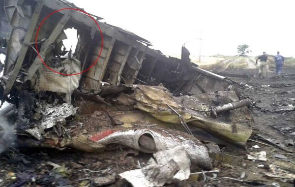 資料圖片:馬航MH17客機(jī)在烏克蘭東部墜毀現(xiàn)場,紅圈處為疑似被彈片擊穿的孔洞。